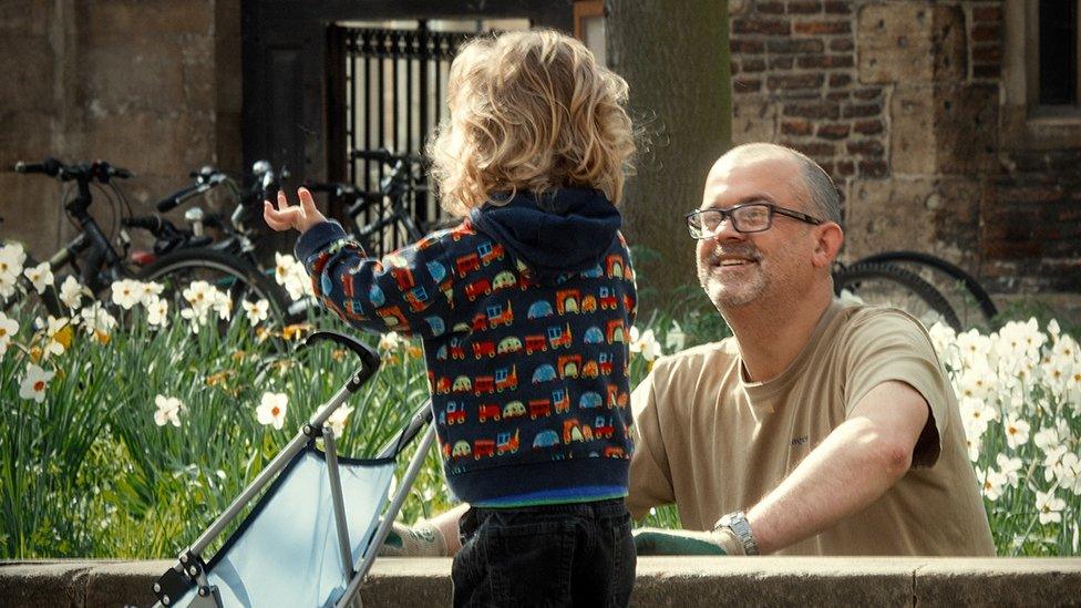 Child with a buggy talking to a gardener