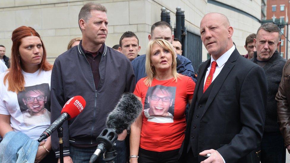 Eamonn Magee Sr and his family speak to the press outside court