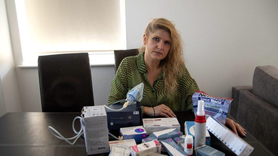 Jorda in her home in Harlsden, London. She is sitting at a table with her medications for severe asthma