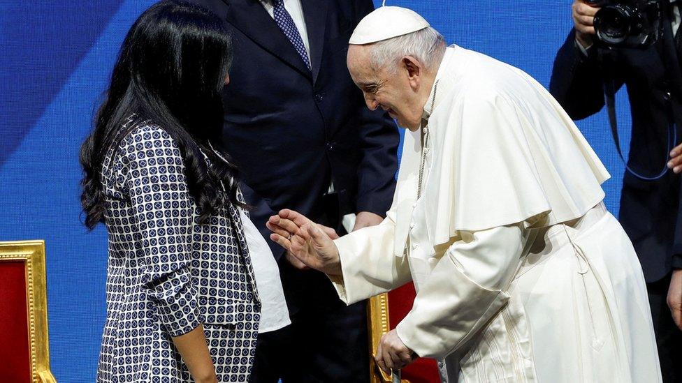 Pope Francis blesses a pregnant woman at the national conference looking at Italy's demographics in Rome