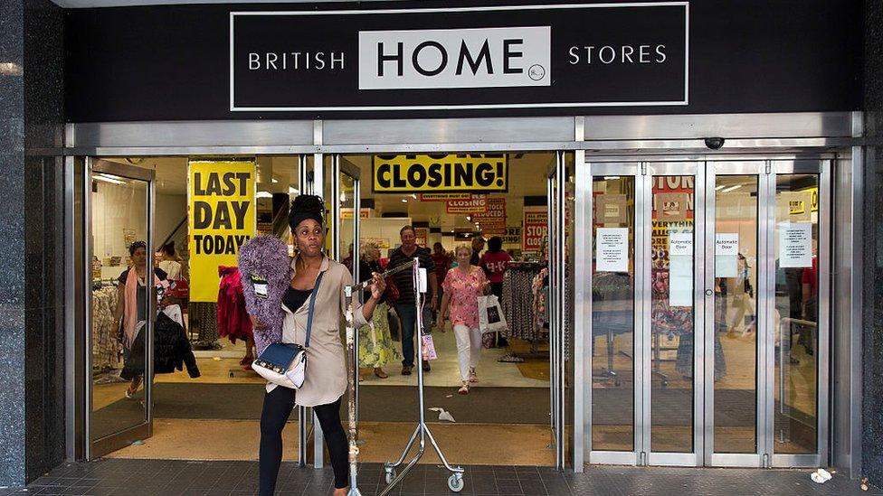 A woman buys a clothing rail during the BHS closing down sale in 2016