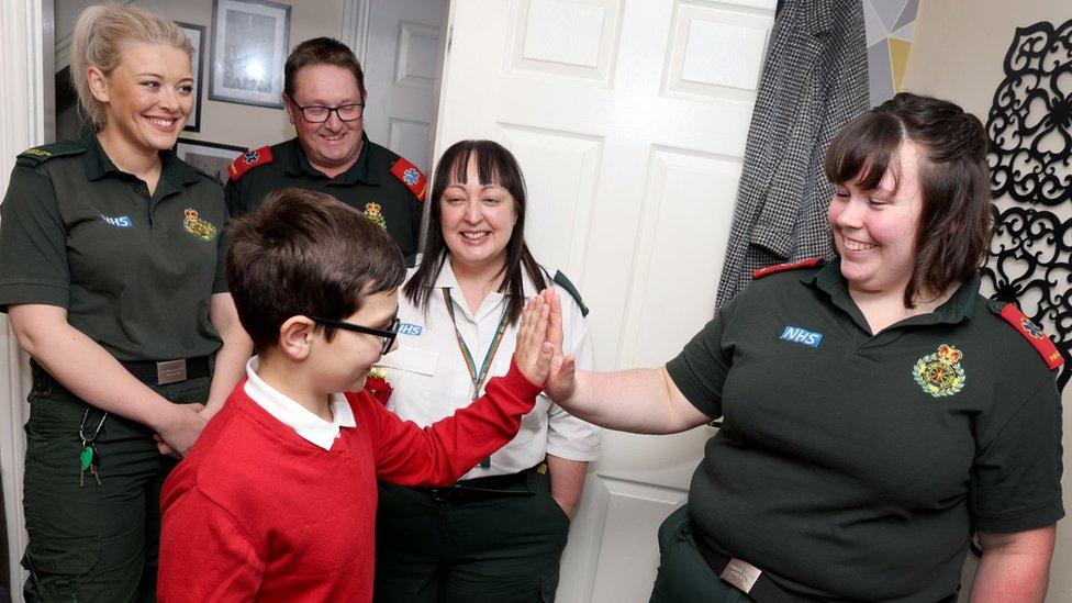 Callum high fives a paramedic as three others look on