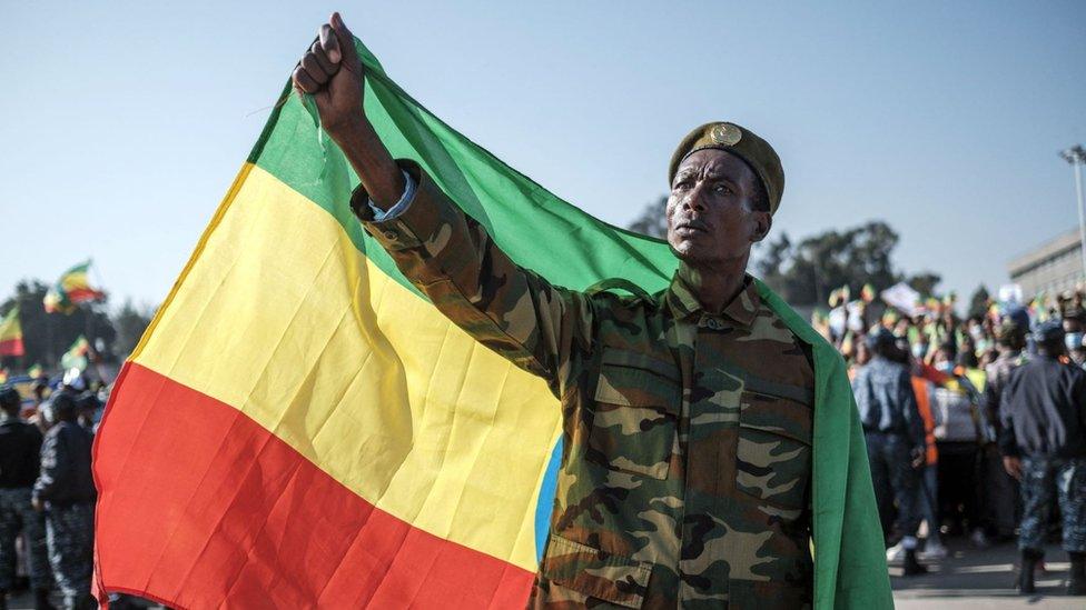 A man in military suit holds an Ethiopian flag during a rally in Addis Ababa, Ethiopia, on November 7, 2021, in support of the national defense forces