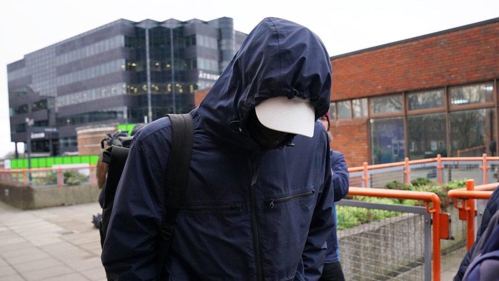 Image of Joseph Watts, 35, with his face covered by a mask, hat and coat hood.