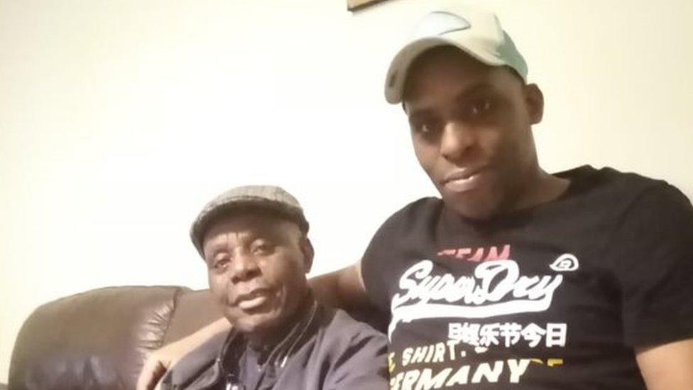 Oladeji Omishore (right) with his arms around his father Alfred Omishore on a sofa