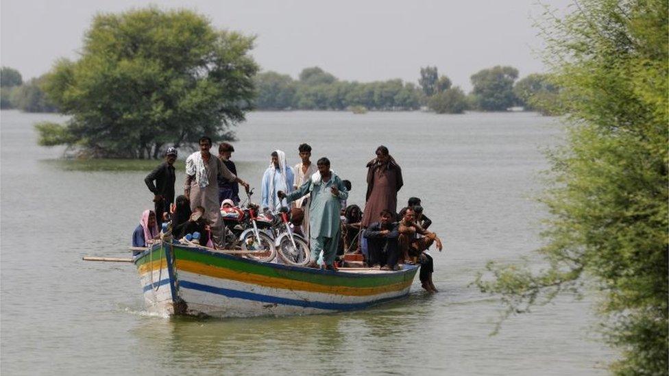 Residents use boat to travel amid flood water, following rains and floods during the monsoon season in Sehwan, Pakistan September 14, 2022.