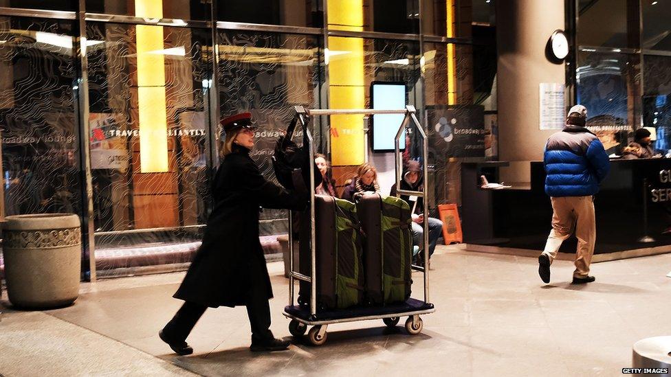 An employee of a Marriott hotel in midtown Manhattan moves guests bags