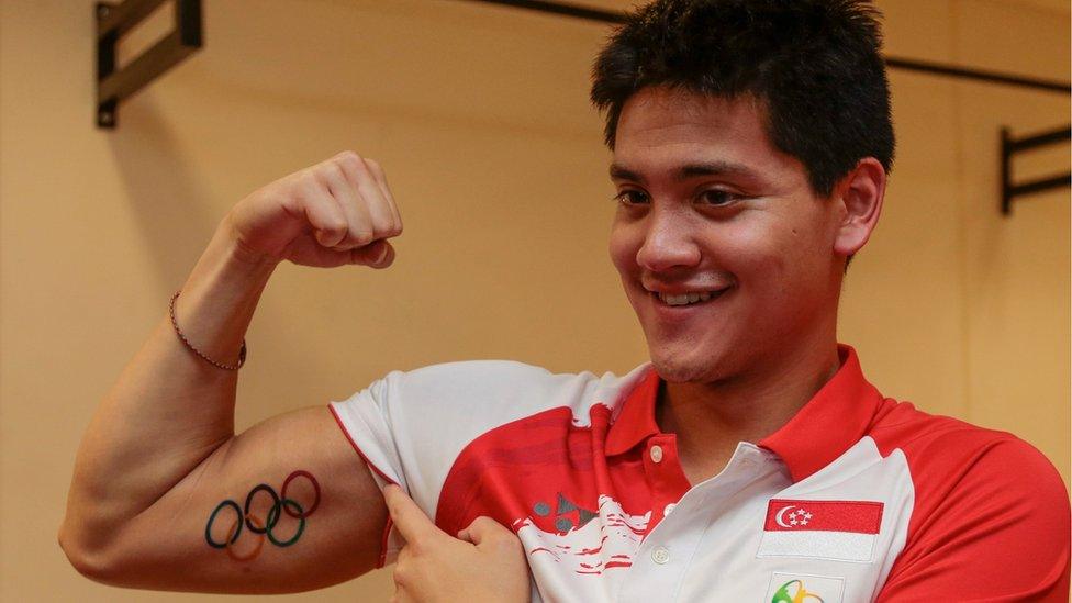 Olympic gold medalist Joseph Schooling of Singapore shows off a fresh tattoo depicting the Olympic logo at the OCBC Aquatic Centre in Singapore, 16 August 2016