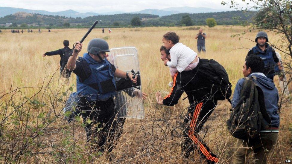 A migrant tries to pass a fence near to the town of Idomeni, on the Greece-Macedonia border on 22 August 2015