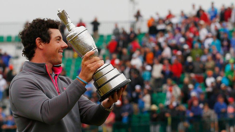 rory mcilroy holds aloft the trophy in front of spectators