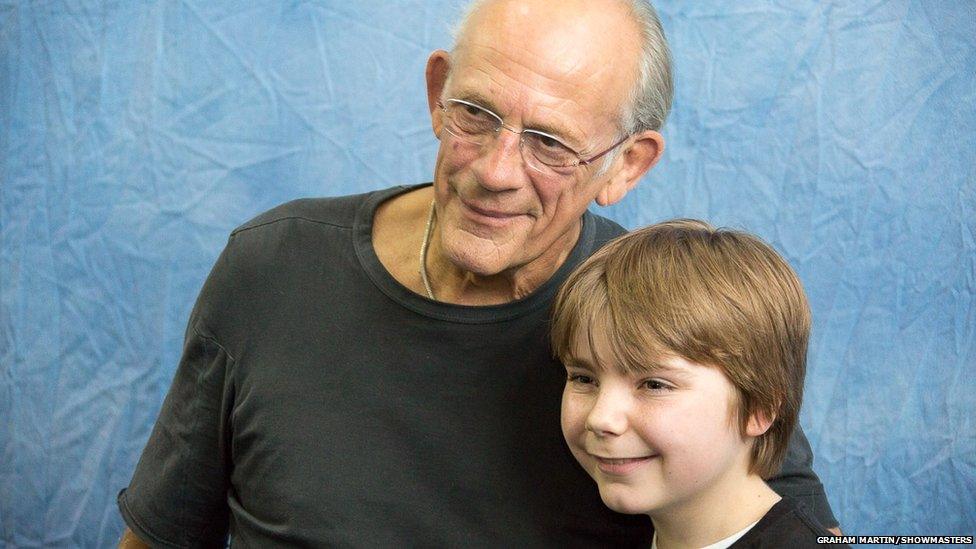 Christopher Lloyd posing with a fan