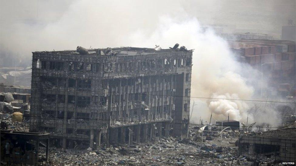 Smoke rises next to a damaged building at the site of the explosions at the Binhai new district in Tianjin, China, August 14, 2015