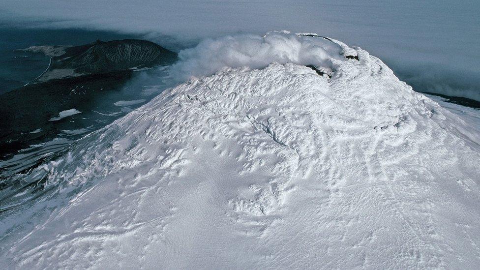 icy-volcano-with-steam-at-crater