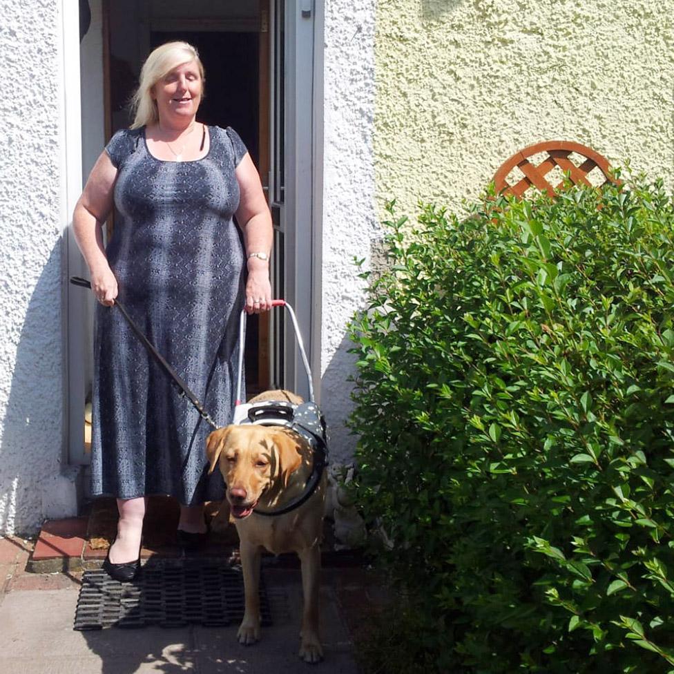 Isabel with guide dog Lucy who is wearing a harness