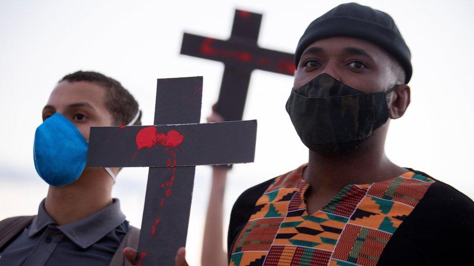 People take part in an anti-government protest following the deadly police raid in the Jacarezinho favela of Rio de Janeiro