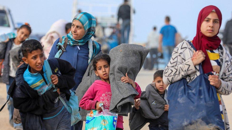 Palestinians, who were displaced by Israel's military offensive on south Gaza, make their way as they attempt to return to their homes in north Gaza through an Israeli checkpoint, amid the ongoing conflict between Israel and Hamas, as seen from central Gaza Strip April 15, 2024.