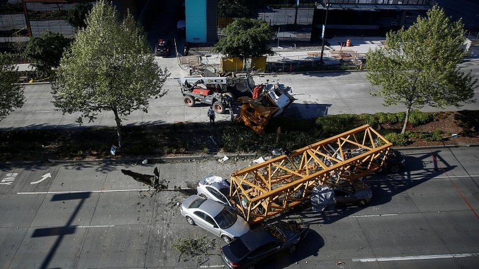 Police inspect cars crushed by part of a construction crane in Seattle, Washington, April 27, 2019