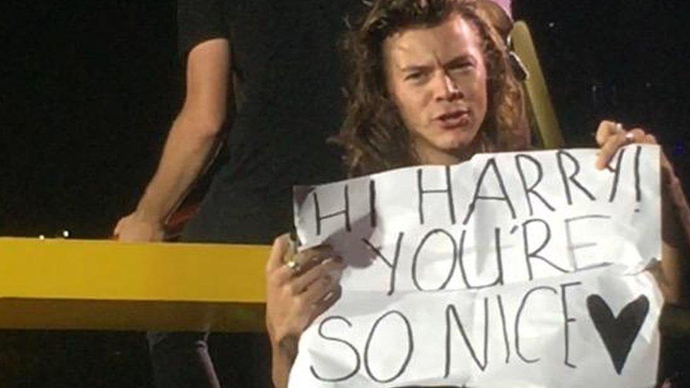 Harry holding up the correctly spelt sign