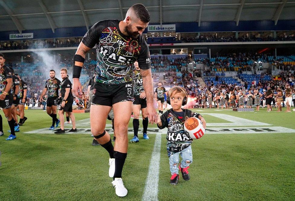 Quaden Bayles, who lives with Achondroplasia, leads the Indigenous All Stars on to the field at a National Rugby League match. 22 February 2020