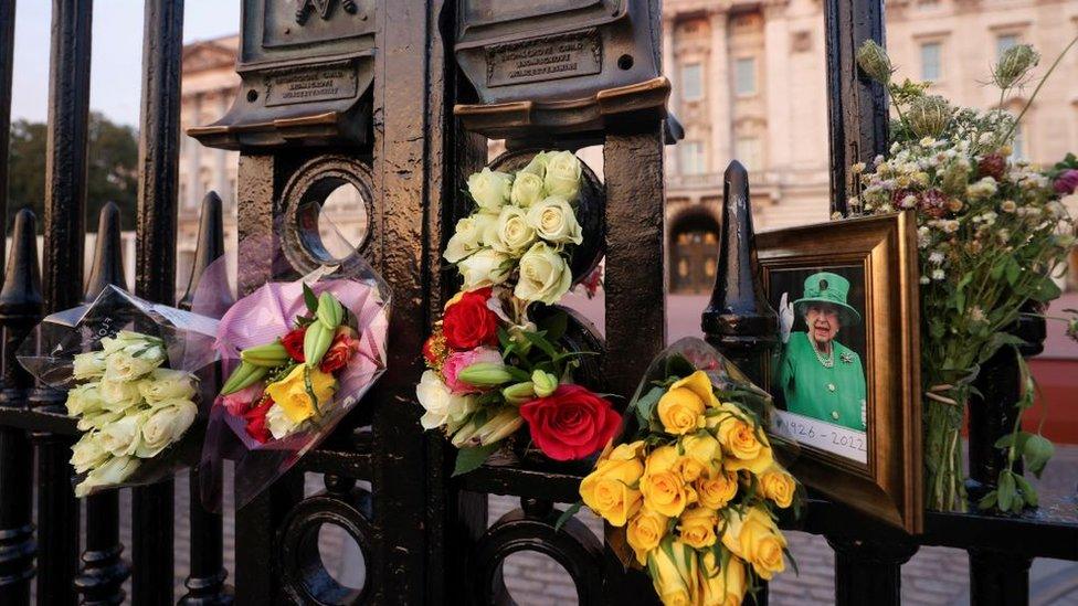 A picture and floral tributes laid outside Buckingham Palace on the first anniversary of the death of Queen Elizabeth II