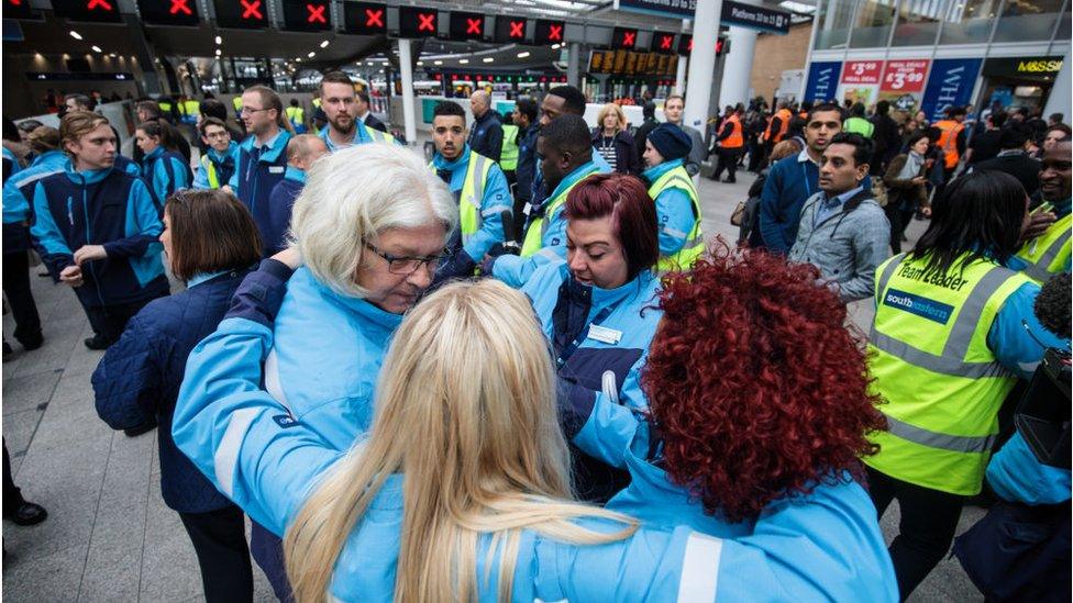 Railway staff embrace during the silence