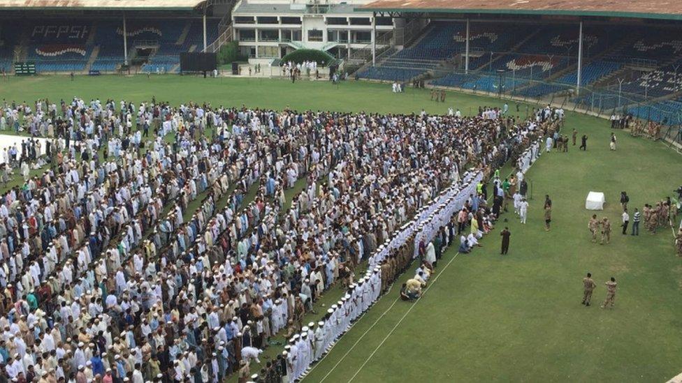 Mourners gather for the funeral in the national stadium in Karachi, 9 July