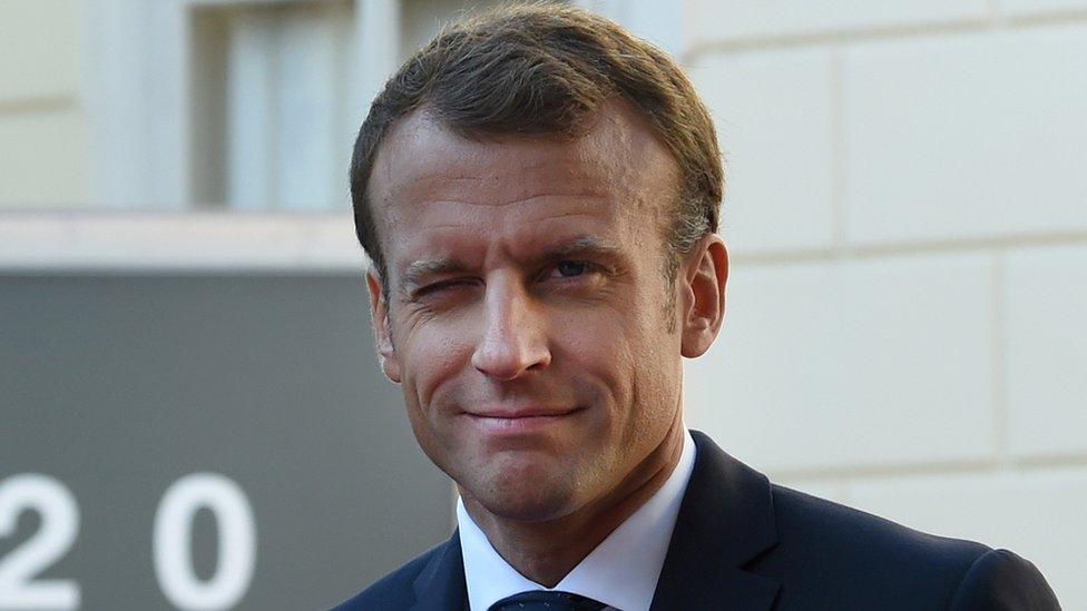 Emmanuel Macron winks at the camera in this portrait shot outside an even of European leaders