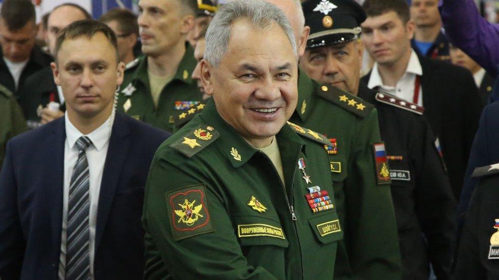 sergei shoigu smiling at an event wearing a military uniform