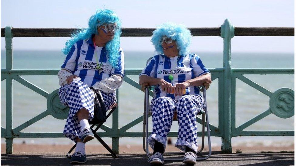 Two fans in wigs