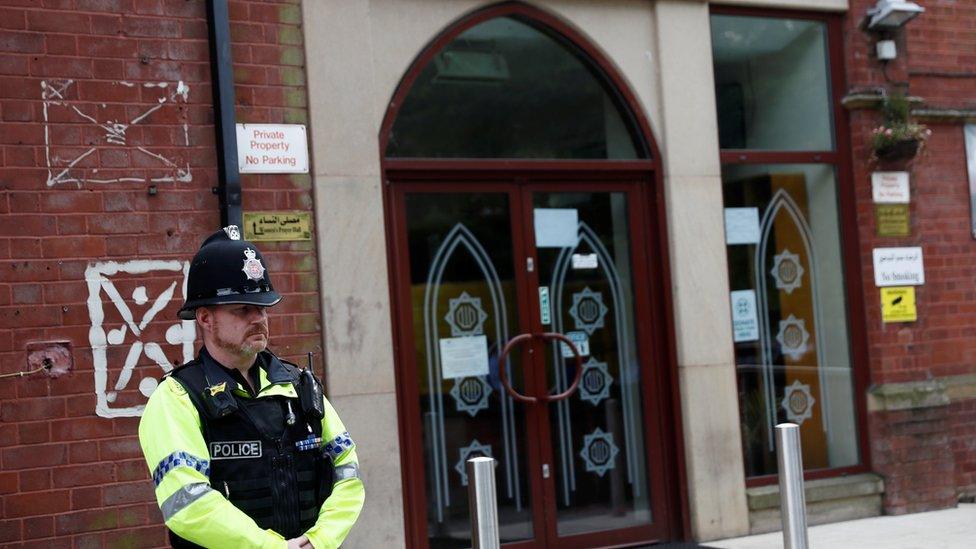 A police officer stands outside Didsbury mosque in Manchester,