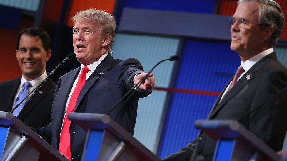 Republican presidential candidates (L-R) Wisconsin Gov. Scott Walker, Donald Trump and Jeb Bush participate in the first prime-time presidential debate hosted by FOX News and Facebook at the Quicken Loans Arena August 6, 2015 in Cleveland, Ohio.