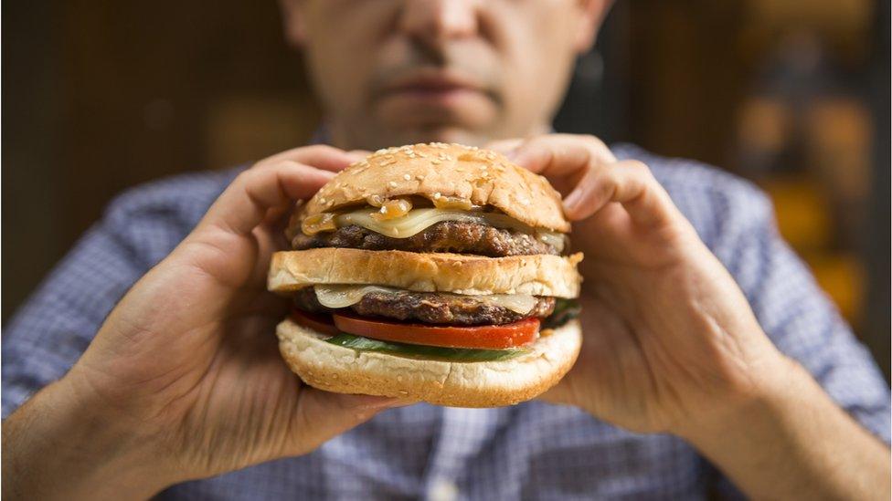 Person holding a burger