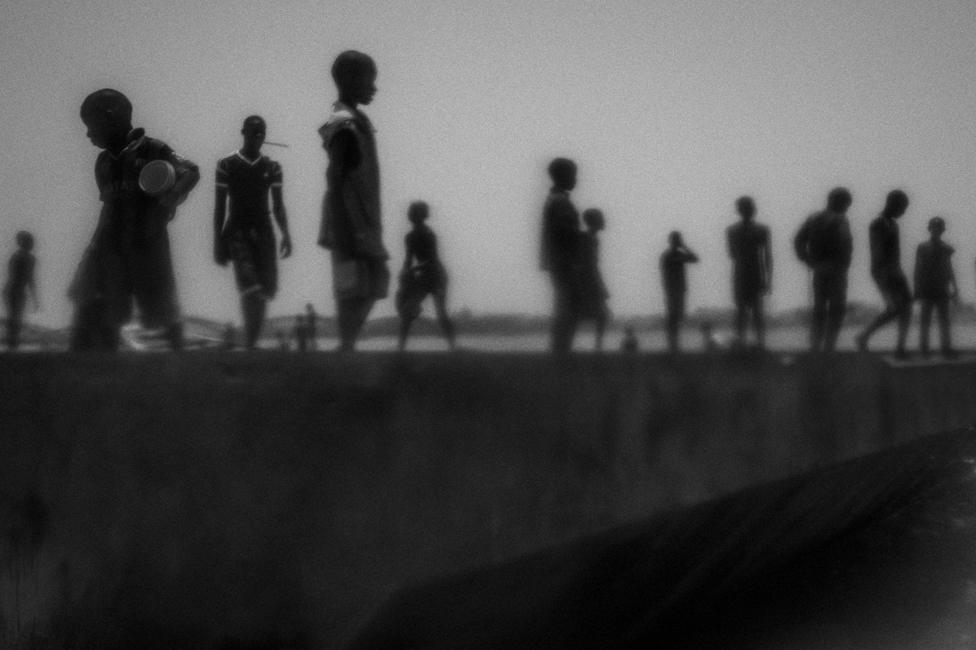 Mario Cruz, Portugal, 2015. Runaway talibes stand on the bank of Senegal river, Saint Louis, Senegal, 20 May 2015