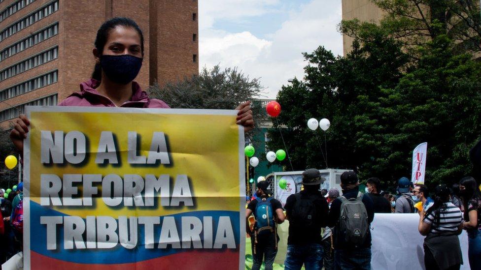 A woman holds sign opposing the tax reform in Bogota, Colombia on April 28, 2021.