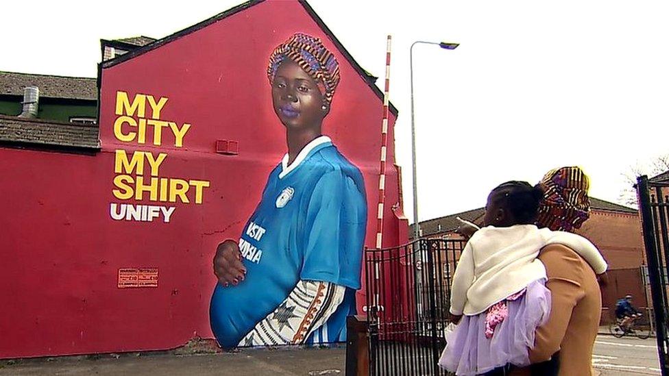 Maimuna Indjai looking at her mural