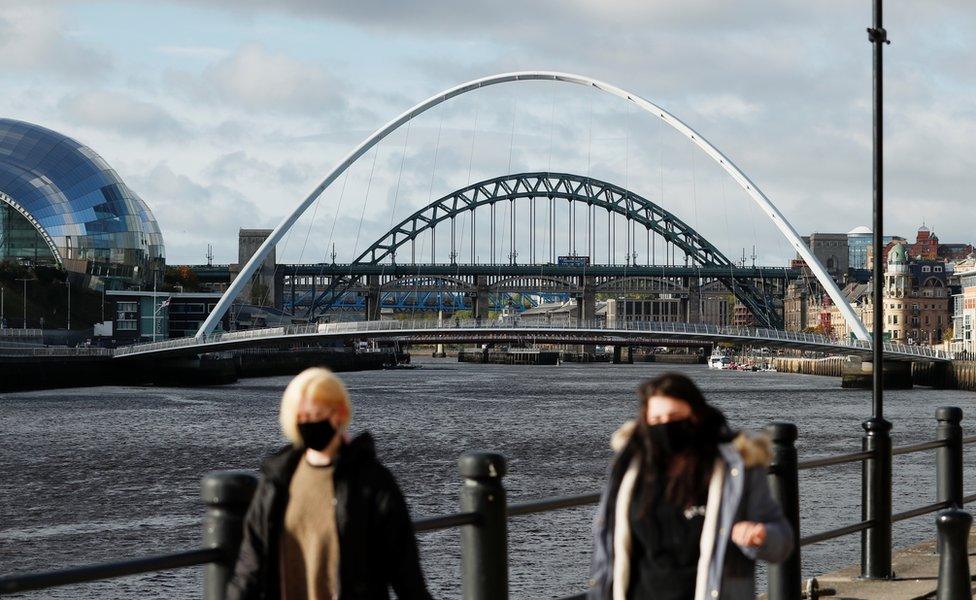 View of two women wearing masks with River Tyne bridges and the Sage Gateshead in the background