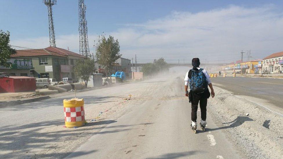 One of the students travelling by roller skate along the road