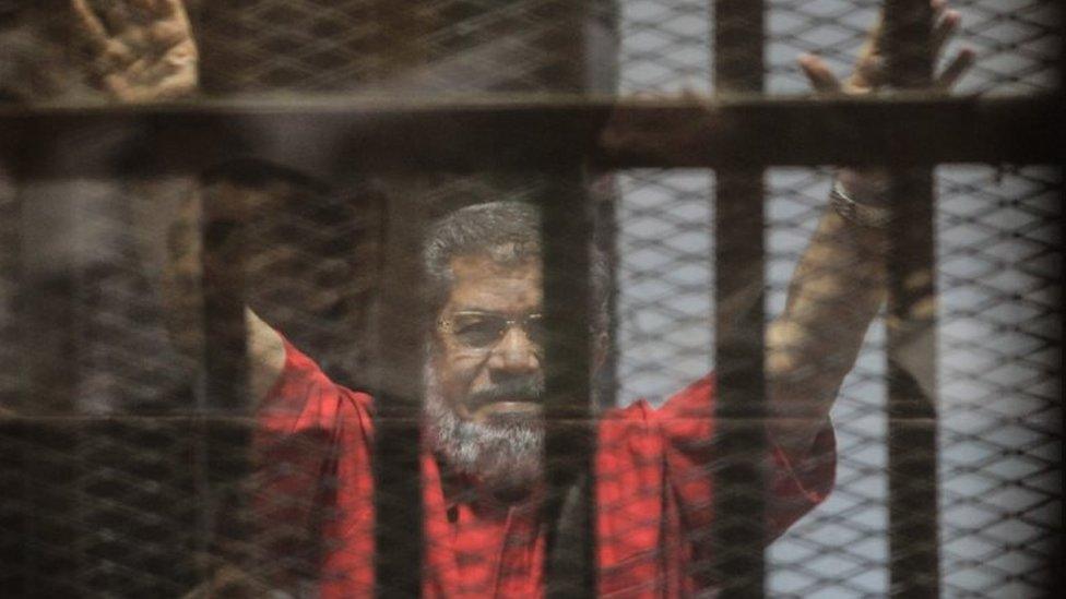 Ousted Egyptian President Mohamed Morsi gestures during a trial session on charges of espionage in Cairo, Egypt, 18 June 2016