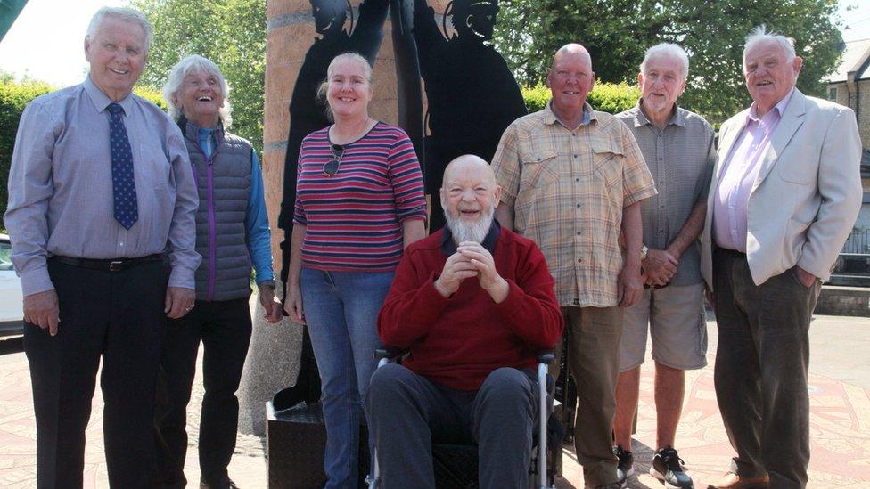 Seven people standing in front of the figures in Radstock