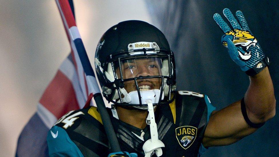 Jacksonville player running out on the field with a British Flag