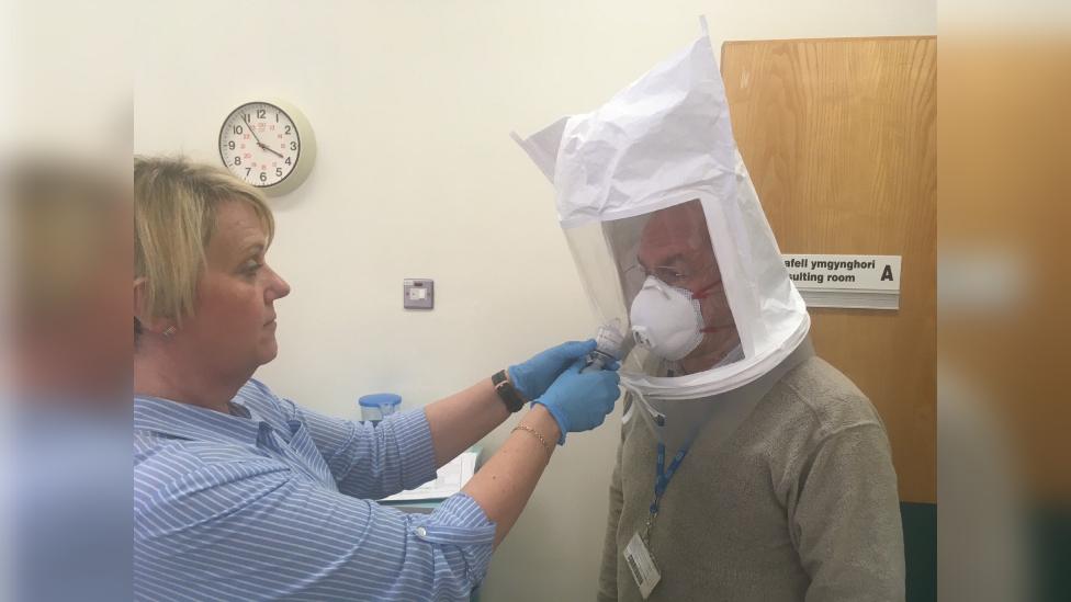 Dr Peter Saul getting PPE fitted