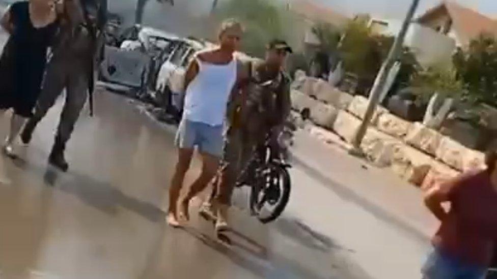 A still from a video apparently showing Dror Kaplun being led away by Hamas gunmen on 7 October