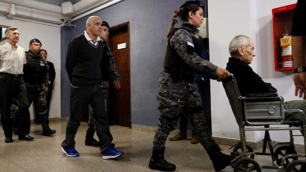 Nicola Corradi (right - in a wheelchair) Armando Gómez (centre) and Horacio Corbacho (left) leave the courtroom in Mendoza, Argentina. Photo: 25 November 2019