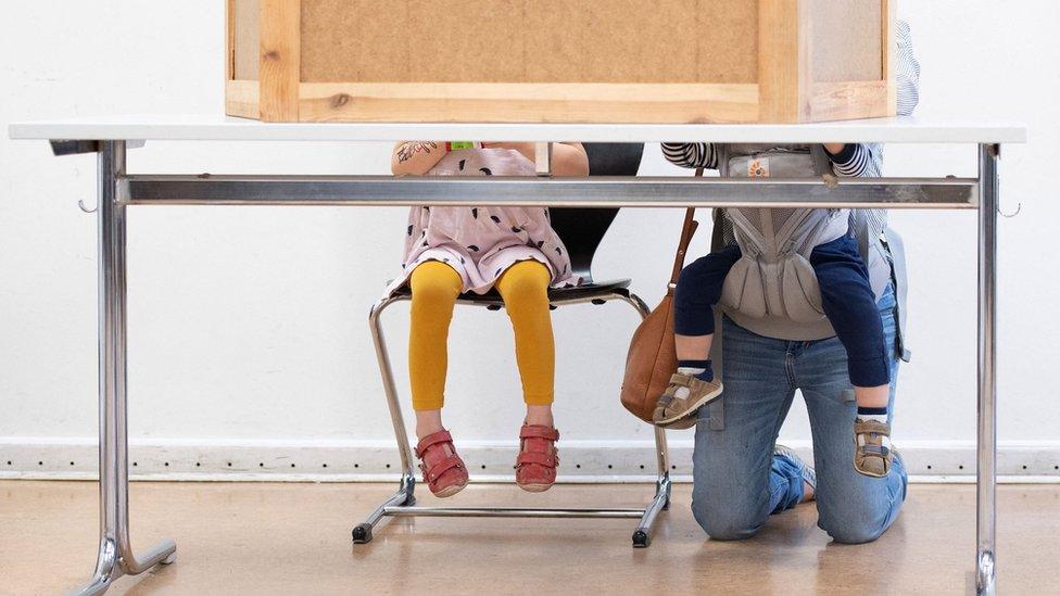 Woman with two young children votes in Berlin in the German federal election (26 September)