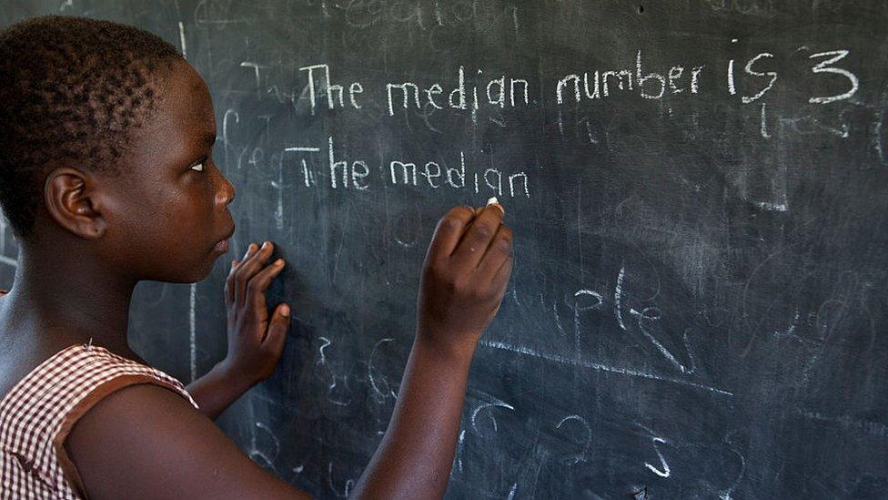 Young girl writing on the blackboard