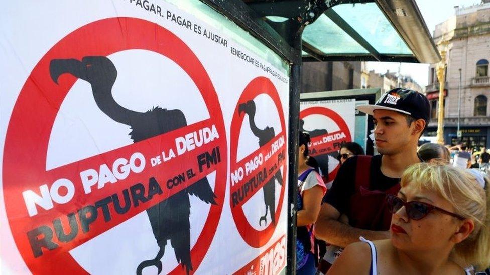 Pedestrians walk past posters on the streets that reads "No to the payment of the debt. Break with the IMF", in Buenos Aires, Argentina February 18, 2020