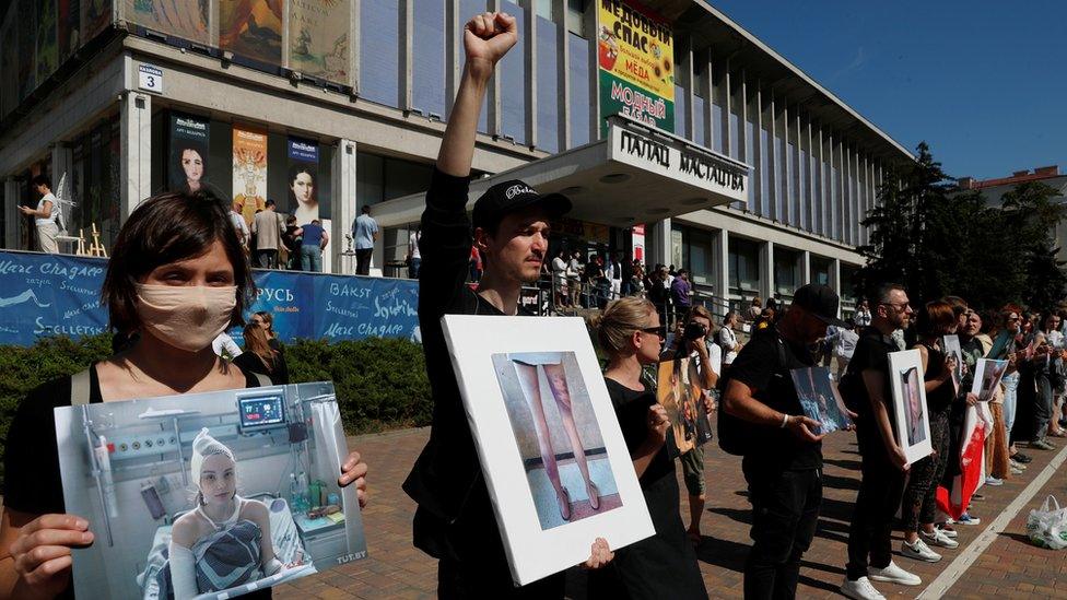 Participants hold pictures of people, who were injured in recent opposition rallies following the presidential election