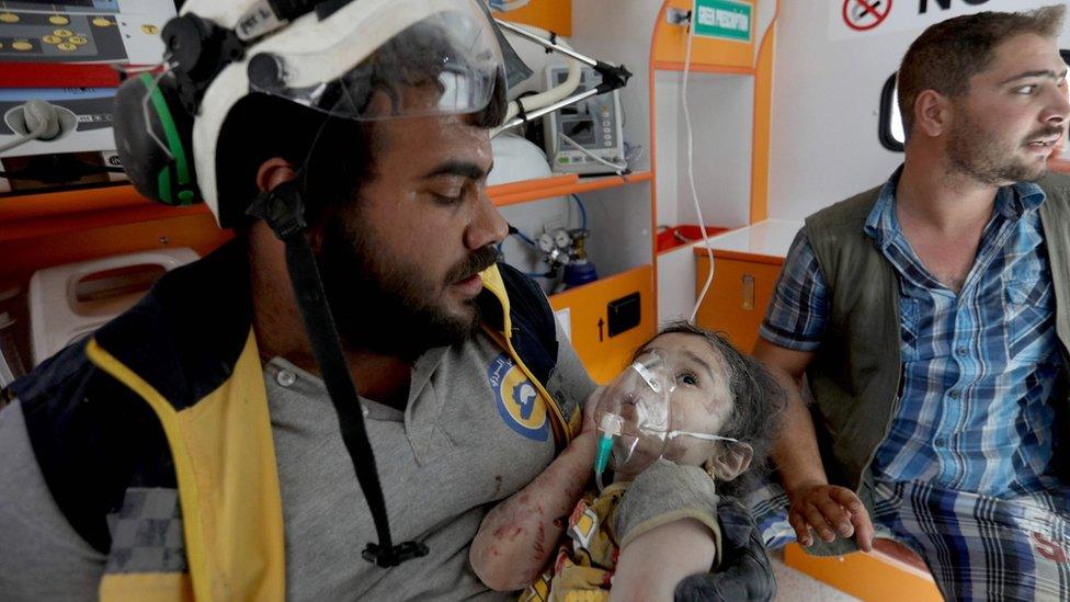 A rescue worker holds a child pulled from the rubble of a destroyed building after an air strike on a market place in the opposition-held town of Maarat al-Numan, Syria (22 July 2019)