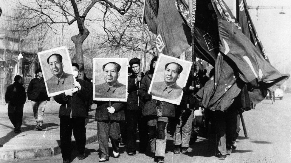 Members of the Red Guards carry large portraits of Mao Tse Tung as they parade through the streets of Beijing, 1967