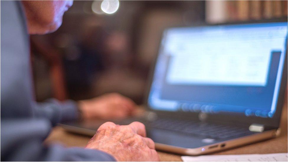 Older man checking computer